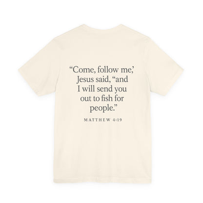 Cream color Christian t-shirt with Matthew 4:19 ‘Come, follow me… I will send you out to fish for people’ back design by Rack & River Outdoors.