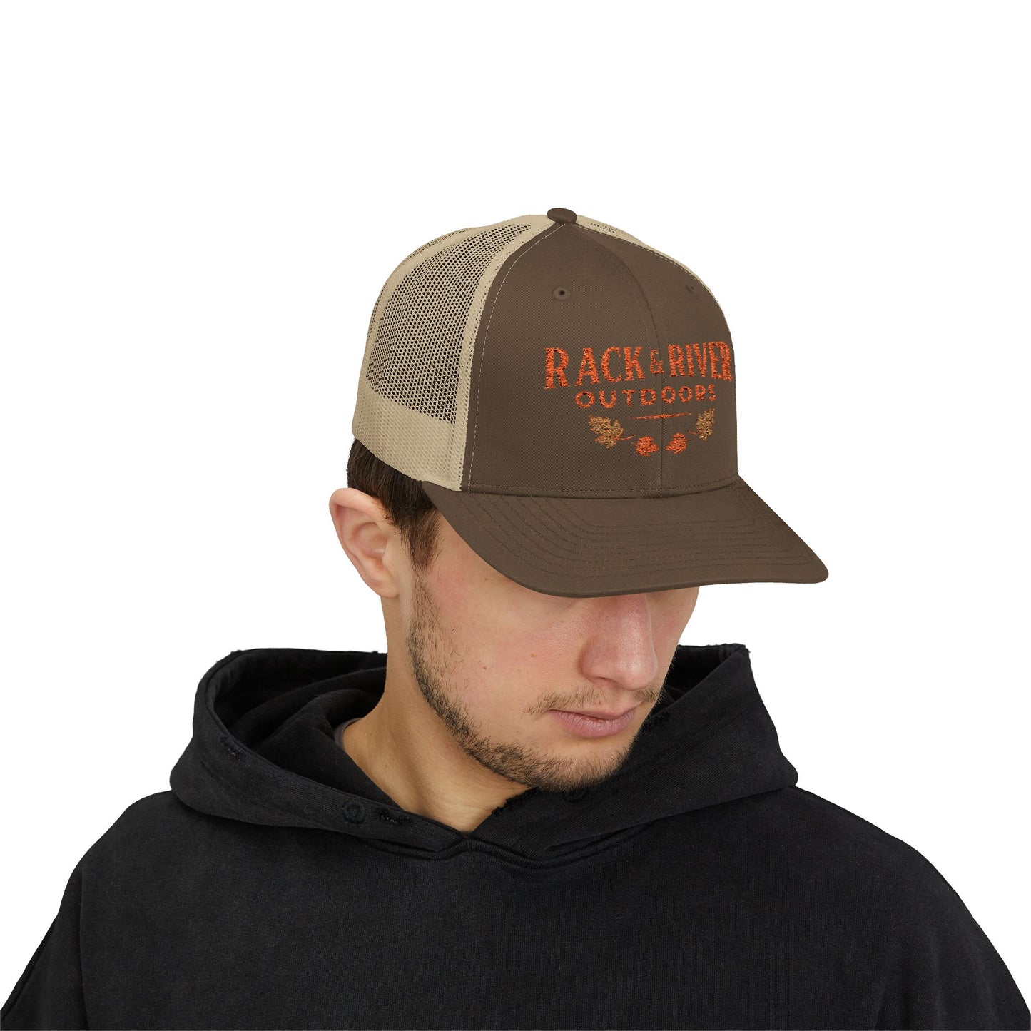 Male model in brown and tan Rack & River Outdoors trucker cap with orange embroidered outdoor logo.