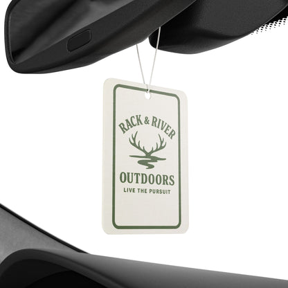 Rack & River Outdoors car air freshener hanging from a rear-view mirror, featuring antler logo and ‘Live The Pursuit’ design.