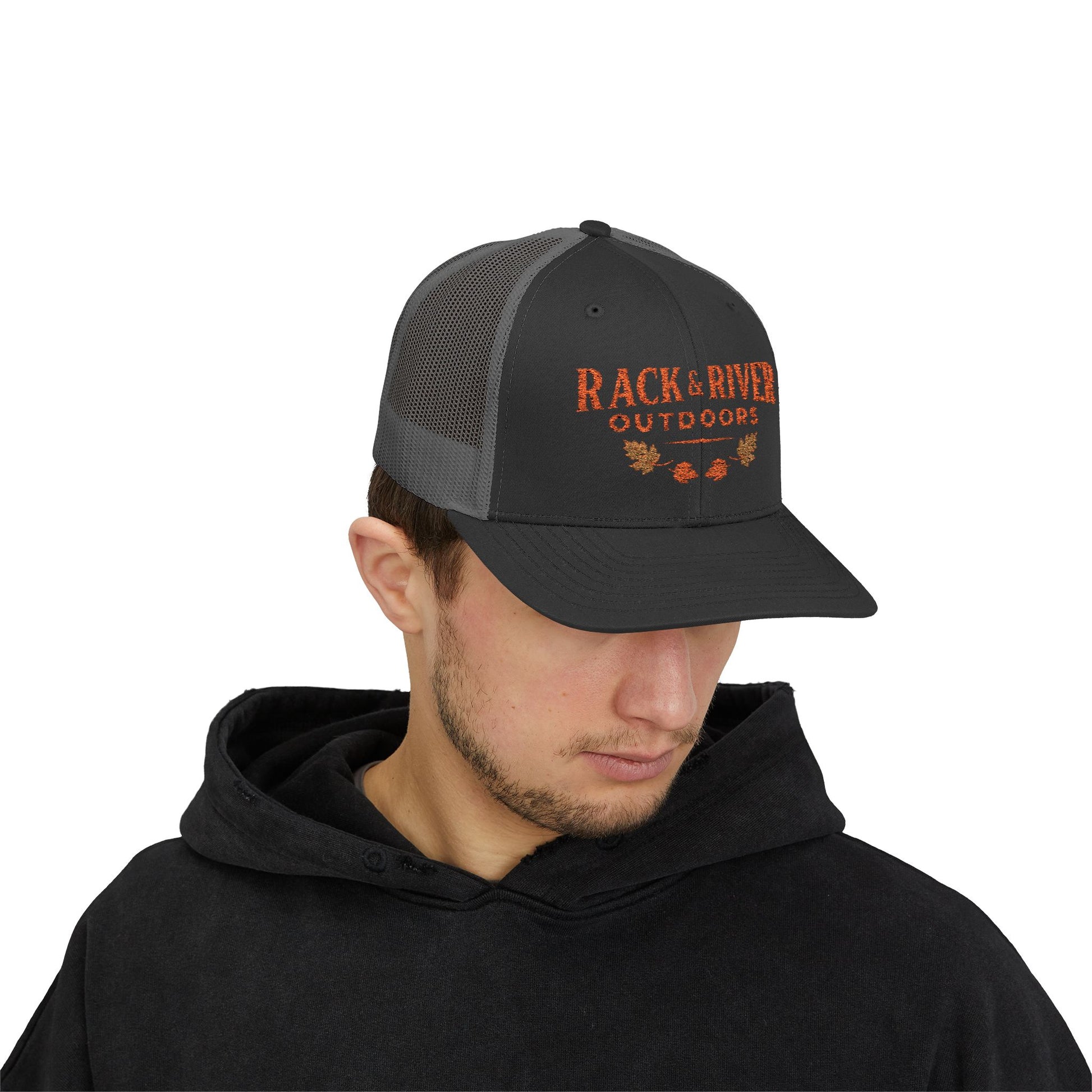 Male model in gray and gray Rack & River Outdoors trucker cap with orange embroidered outdoor logo.