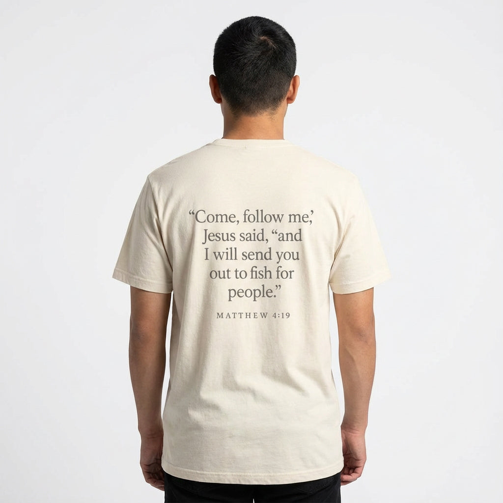Model wearing sand color Rack & River Outdoors Matthew 4:19 Christian t-shirt with back scripture graphic.
